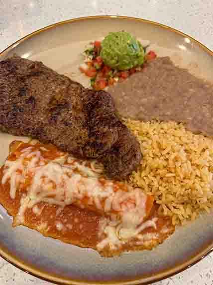 Authentic Carne a la Tampiqueña featuring grilled beef steak, cheese enchilada, and guacamole, a Tex-Mex favorite in the heart of Frisco at Tequileros restaurant.