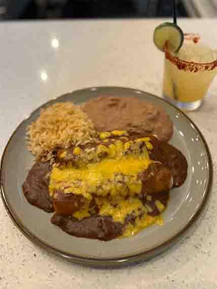 Classic Number 7 plate with two beef enchiladas, served with fluffy Mexican rice and refried beans, a popular choice at Tequileros Tex-Mex restaurant.