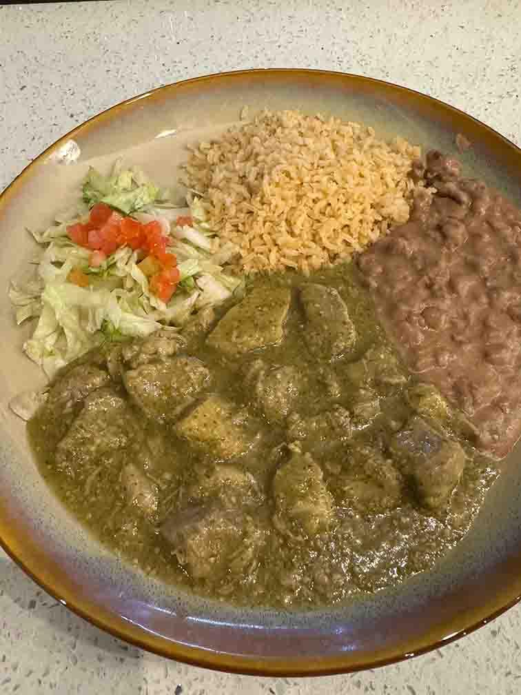 Puerco en Chile Verde featuring tender pork simmered in a spicy green chile sauce with a hint of citrus, served with rice and beans at Tequileros restaurant in Frisco, Collin County, Texas.